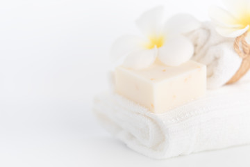 Fototapeta na wymiar White towels,organic soap and Plumeria flower over white background,spa concept