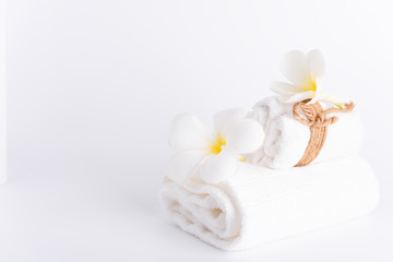 Fototapeta na wymiar White rolled towels decorate with Frangipani flowers spa object on white background