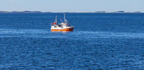 Small orange white fishing boat