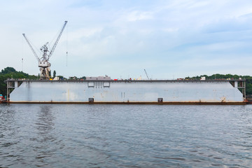 Fototapeta premium Floating gray dry dock with ship