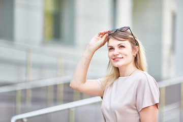 Portrait of a romantic woman with sunglasses who smiles sincerely on a sunny day in spring.