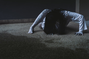 Ghost Woman Horror scene Death movie with Halloween Makeup lying on Floor in Darkroom.