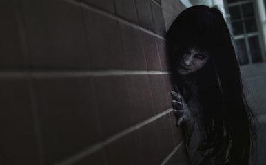 Fototapeta Ghost Woman Horror scene Death movie with Halloween Makeup holding side wall in Darkroom. obraz
