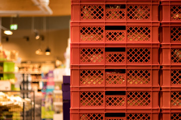 Red bread crates stacked in a supermarket.