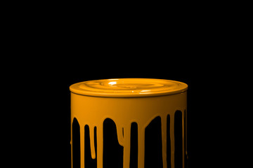 Orange paint flowing down on wall of metal bucket. Isolated over black background