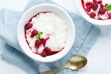 Vegan Coconut Rice Pudding. Vegan diet breakfast with coconut milk, raspberry, scandinavian minimalism, top view, copy space