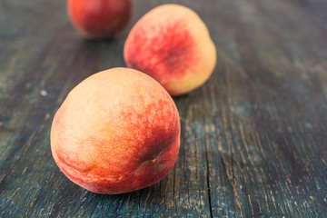 Fresh ripe peaches on dark wooden table.