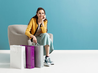 Happy woman sitting on an armchair after shopping