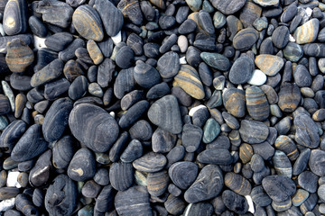 Wet Black pebble stones island in Koh hin ngam, Tarutao National Park, Satun, Thailand