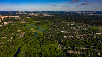 aerial photo of the town in the forest near the river with cumulus clouds