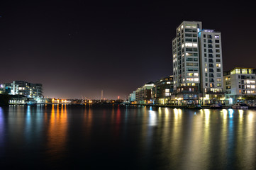 Fototapeta na wymiar Buildings reflected on water at night