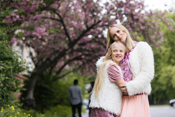 Mother and little daughter playing together in a park 