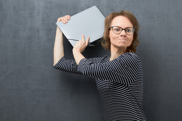 Portrait of woman trying to hit somebody using folder
