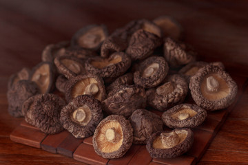 Fototapeta na wymiar dried mushrooms lie on a wooden dark colored surface and blackboard