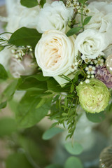 Wedding table setting is decorated with fresh flowers and white candles. Wedding floristry. Bouquet with roses, hydrangea and eustoma