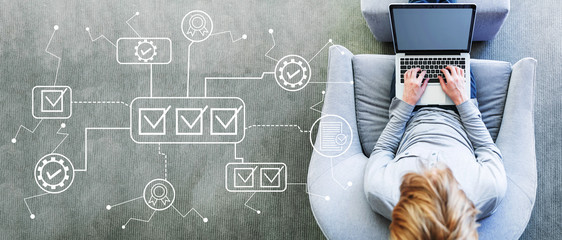 Quality control approval with man using a laptop in a modern gray chair