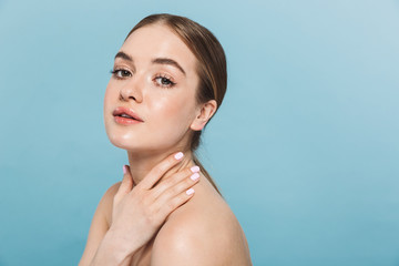 Pretty young woman posing isolated over blue wall background.