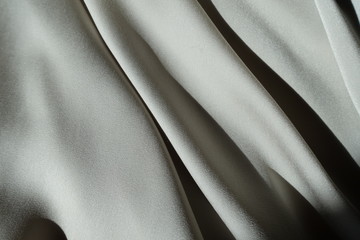 Diagonal soft folds on light grey chiffon fabric