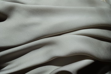 Fototapeta na wymiar Draped thin shiny light grey chiffon fabric