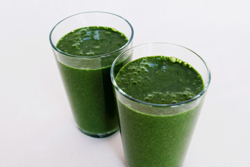 Fresh green smoothie with kale leaves, banana, coconut milk, spirulina and flax seeds on white background. Healthy food
