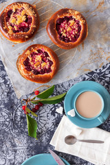 Table with yeasty sweet pastry with fresh cherries and streusel topping, cup of tea and few cubes of sugar. Summer fresh fruit appetizer.