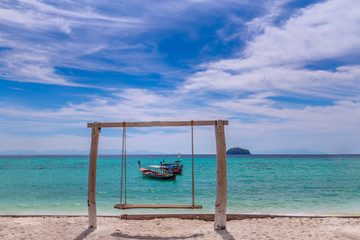 Long tail boat on white sand beach on tropical island in thailand