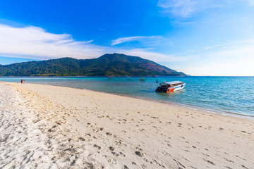 Fototapeta na wymiar Long tail boat on white sand beach on tropical island in thailand