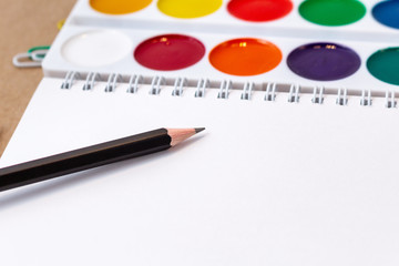 notebook blank page pencil watercolor  mock-up composition Back to school concept with stationery office supplies on a brown craft paper background copy space top view