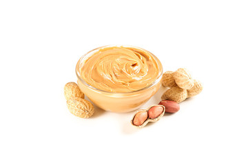 Creamy peanut butter in glass bowl and peanut isolated on white background. A traditional product of American cuisine