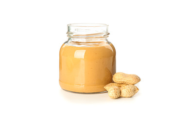 Creamy peanut butter in glass jar and peanut isolated on white background. A traditional product of American cuisine