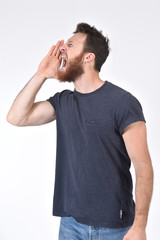 man putting a hand in mouth and is screaming on white background