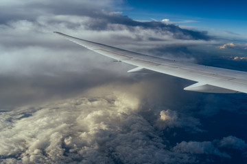 Fototapeta na wymiar Scenic sky view from the airplane window. Beautiful clouds and airplane wing. Travel concept