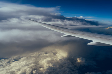 Beautiful sky with white clouds and airplane wing. View from window.