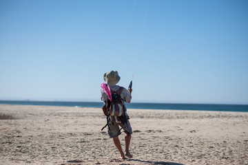 Man on beach kite surfing