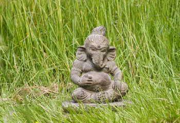 Ganesh stone statue in the green grass