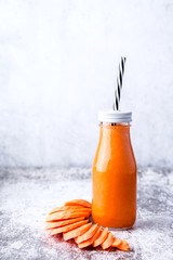 glass bottle with carrot smoothie