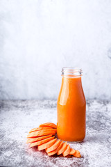glass bottle with carrot smoothie