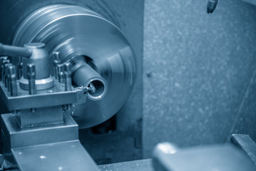 The lathe machine cutting the steel tube. The metal working in the factory.