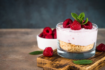 No baked cheesecake with raspberry in glass jar.