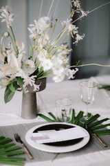 wedding bouquet on a table with a white tablecloth and dry wood
