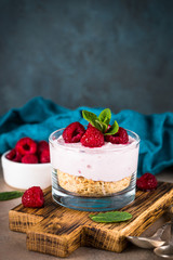 No baked cheesecake with raspberry in glass jar.