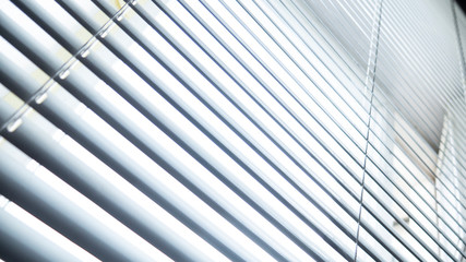 White blinds on the window. Sunlight from the window through the blinds