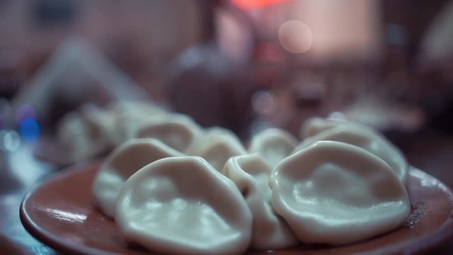 Close up of spinning plate of delicious khinkali dumplings seasoned with chili pepper