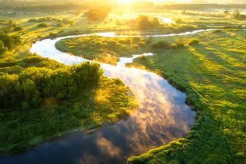 Summer nature background. Scenic sunny river at sunrise view from above. Beautiful bright nature landscape of riverside aerial view. Sunny morning on river