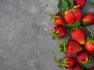 Fresh red strawberries on a gray background with copy space. Top view.