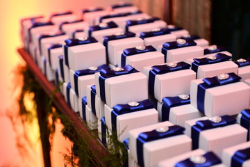 Fototapeta premium happily married in white boxes on candy table in ballroom, candy in the box, party sweets, candy table, blue satin ribbon