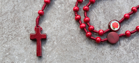 Red rosary on a stone background