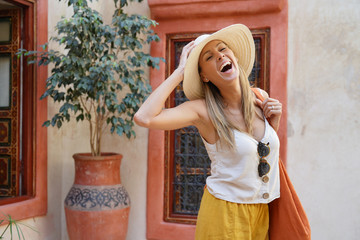 Stylish woman laughing in traditional Moroccan riad