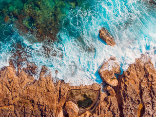 Mediterranean Sea with turquoise water beats on coast of island of Malta. Aerial top view