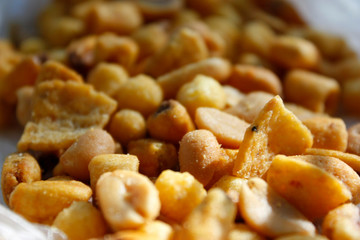 Golden mixed nuts, snacks, chips for beer close-up with selective focus.